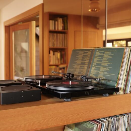 Sonos Amp next to a turntable on top of a wooden record case.