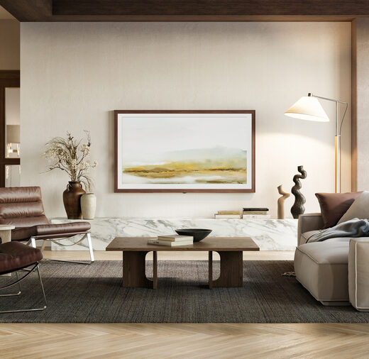 A stylish modern living room with neutral tones, featuring a wall-mounted frame TV, contemporary furniture, and natural light from large windows.