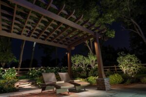 Outdoor patio illuminated by landscape lighting at night.