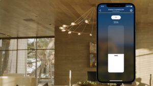 A smartphone displaying the Josh.ai lighting control interface, layered over an image of a modern living space.