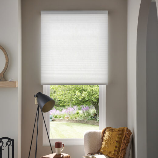 A home interior with Lutron cellular shades lowered halfway on a window.