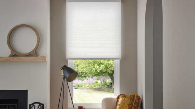 A home interior with Lutron cellular shades lowered halfway on a window.