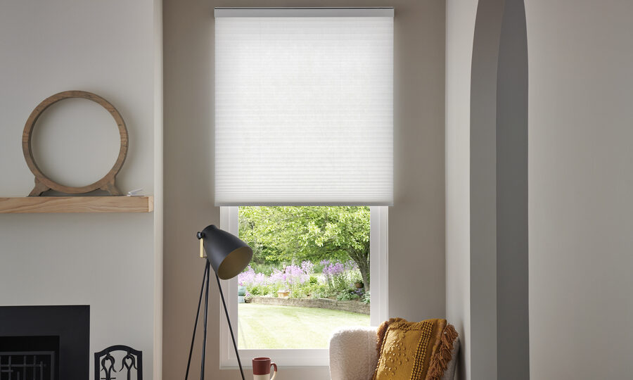 A home interior with Lutron cellular shades lowered halfway on a window.